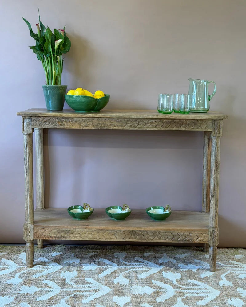 Console table with fluted-carved apron and legs in natural mango wood, styled with lemons, glassware and a jug