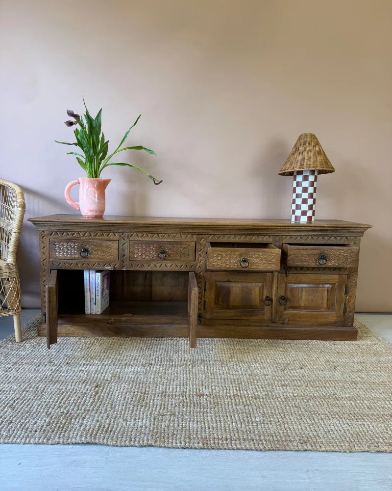 Carved wood sideboard, angled view with one door open revealing an internal shelf with books