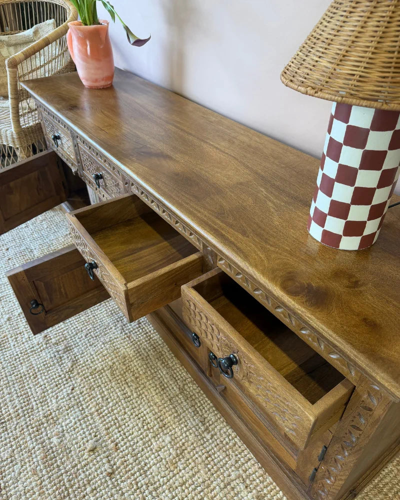 Close-up of open drawers on a carved wood sideboard, showing the natural wood interior